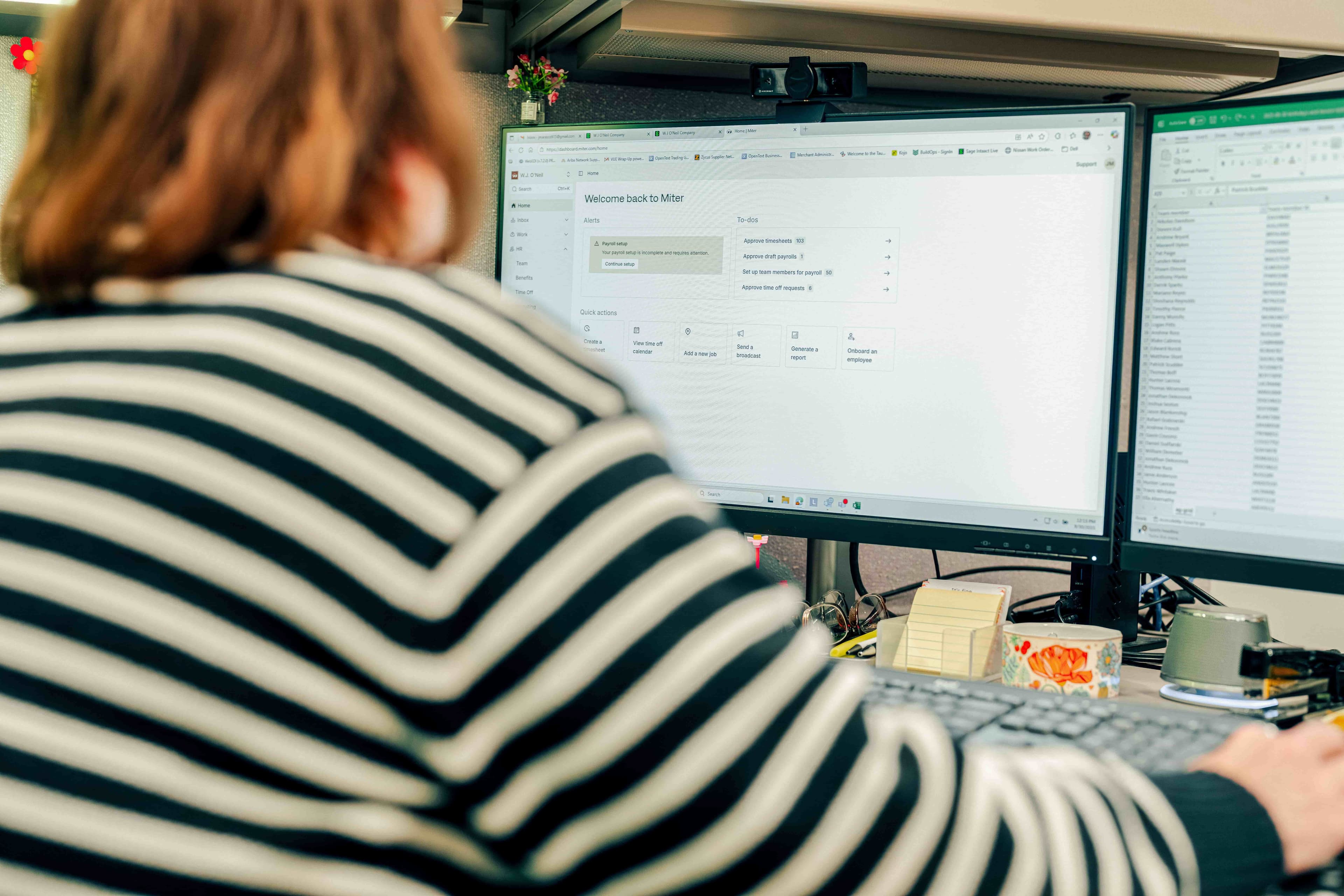 A payroll manager reviewing certified payroll data on a laptop.