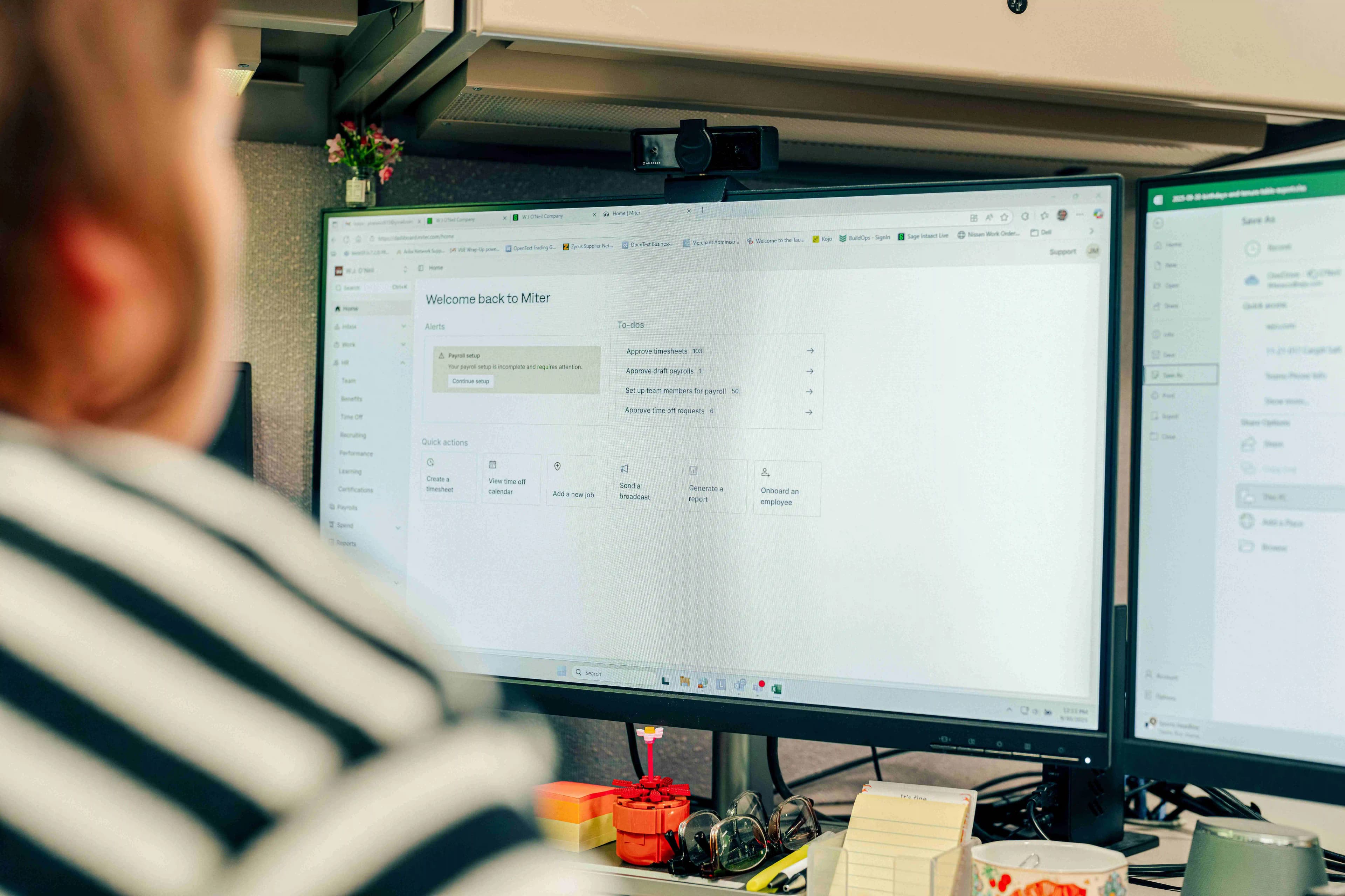A person sitting at her desk with a closeup shot of the computer screen showing the miter dashboard