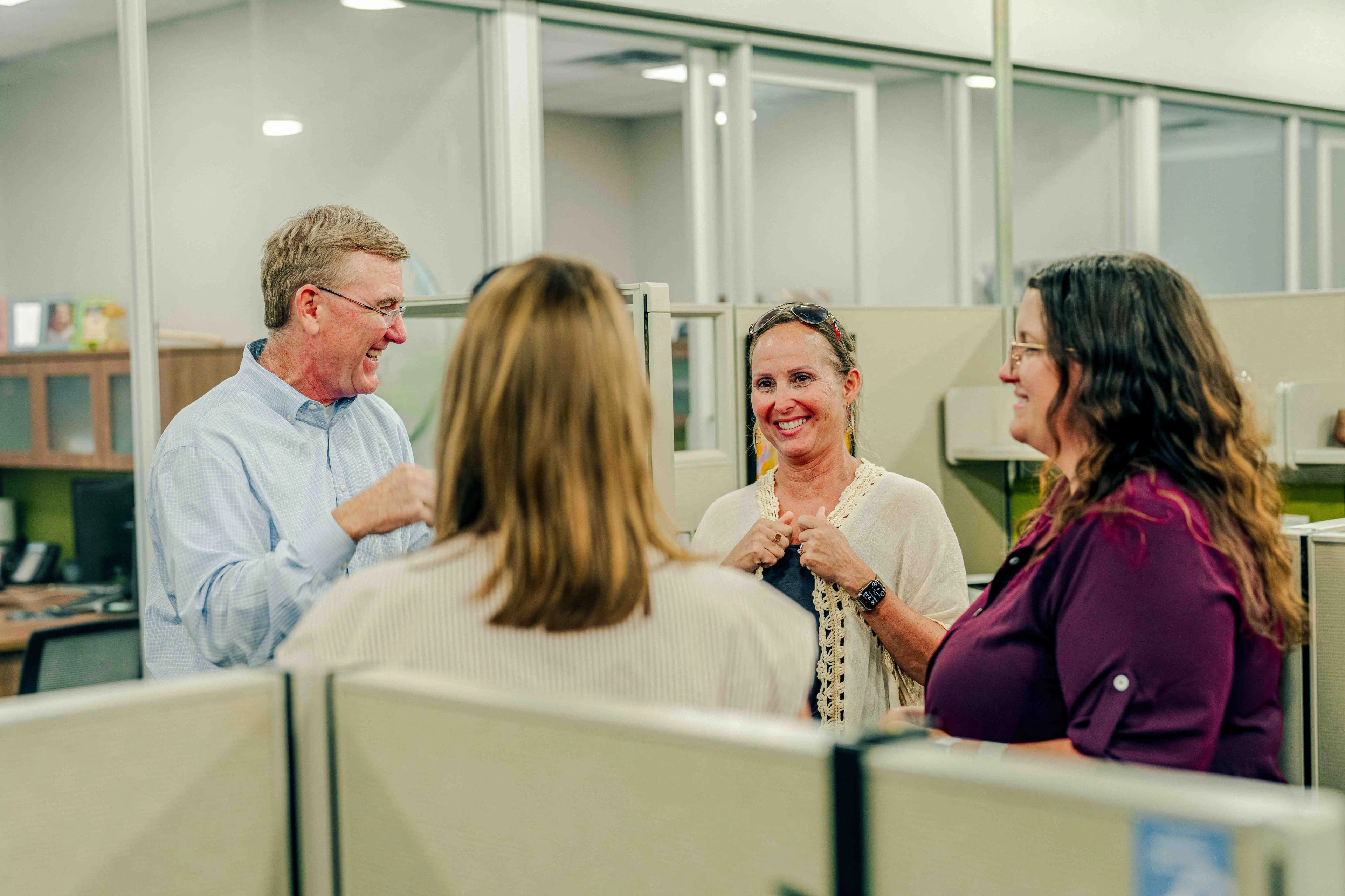 A group of colleagues standing in a group having a chat.