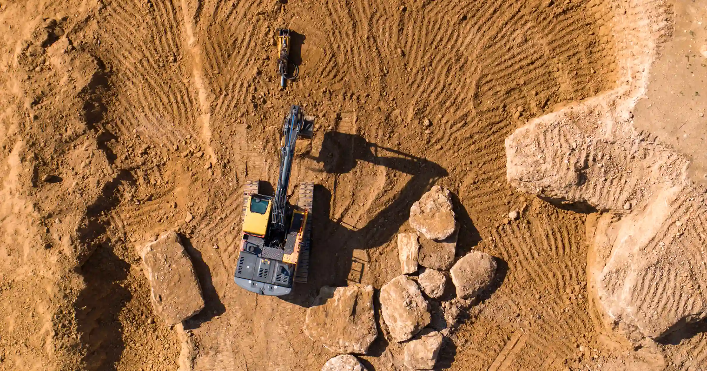Sky view of construction heavy operating vehicle working on dirt and moving large builders